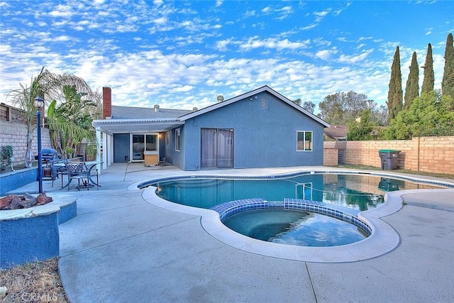 view of pool featuring a pool with connected hot tub, a patio area, fence, and a pergola