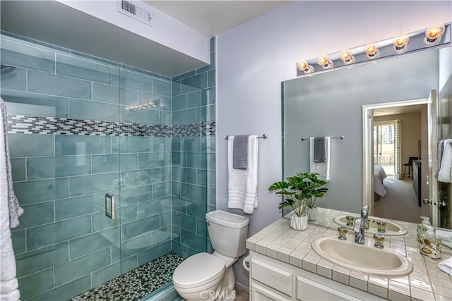 bathroom featuring toilet, a shower stall, visible vents, and vanity