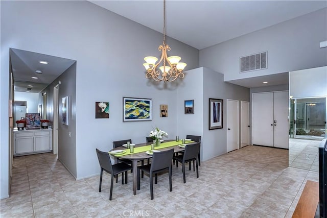 dining area featuring visible vents, a high ceiling, and an inviting chandelier