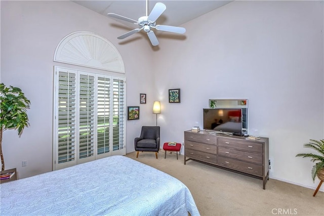 carpeted bedroom featuring a towering ceiling and a ceiling fan