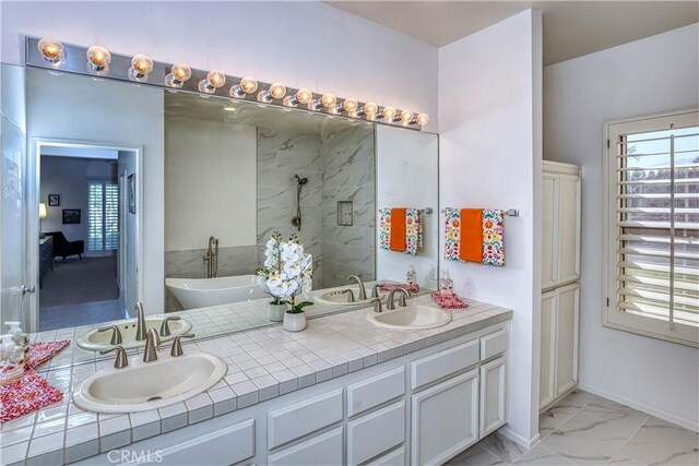 full bath featuring a wealth of natural light, marble finish floor, and a sink