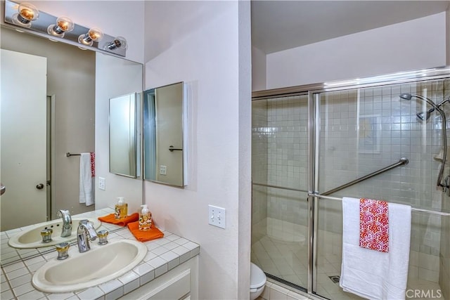 bathroom featuring toilet, a stall shower, and vanity