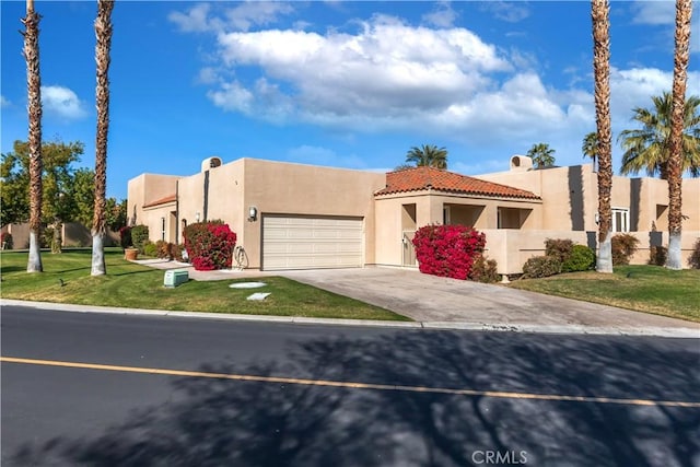 view of front facade featuring a front yard, driveway, an attached garage, and stucco siding