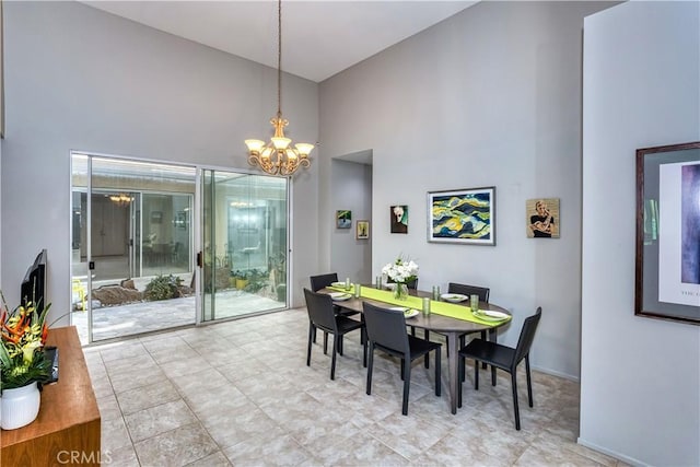 dining area featuring a high ceiling and a notable chandelier