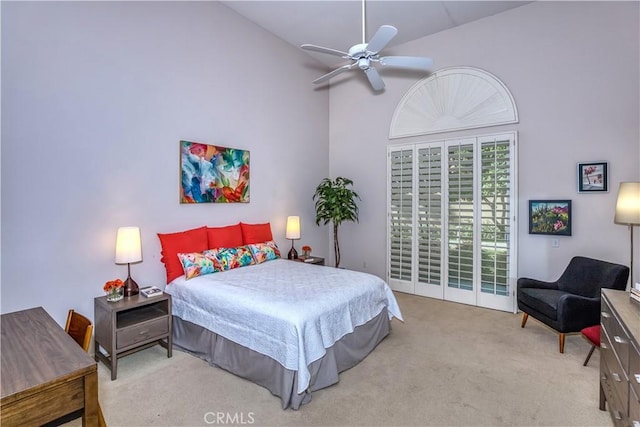 carpeted bedroom with a ceiling fan and a high ceiling