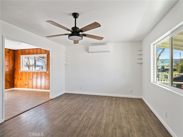 empty room with wood finished floors, wooden walls, baseboards, and a wall mounted AC