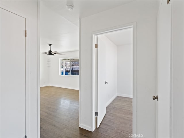 hall with dark wood-style floors and baseboards