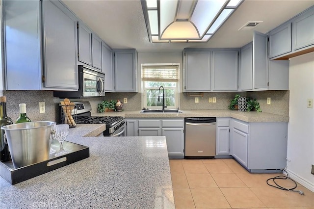 kitchen featuring light countertops, visible vents, appliances with stainless steel finishes, light tile patterned flooring, and a sink