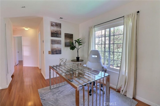 office area featuring visible vents, baseboards, and wood finished floors