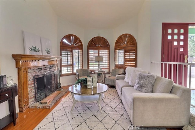 living area with light wood-type flooring and a brick fireplace