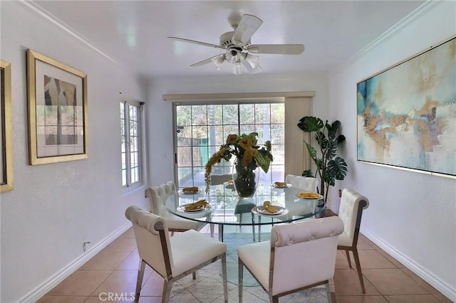 dining space featuring ornamental molding, tile patterned flooring, a ceiling fan, and baseboards