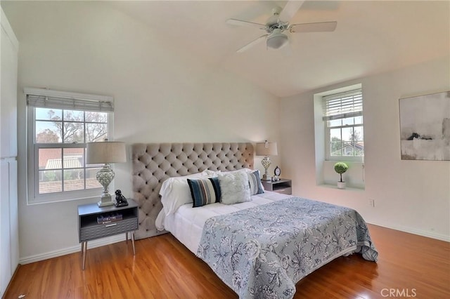 bedroom featuring lofted ceiling, baseboards, and wood finished floors