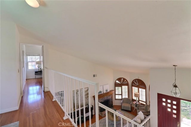 hall featuring lofted ceiling, visible vents, and wood finished floors