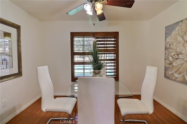 dining space featuring a ceiling fan, baseboards, and wood finished floors