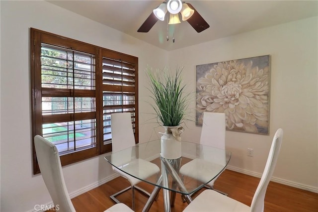 dining area featuring a ceiling fan, baseboards, and wood finished floors