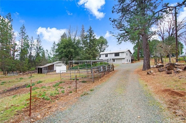 view of street featuring a pole building and gravel driveway