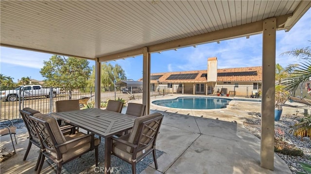 view of patio with outdoor dining area, a fenced in pool, and fence private yard