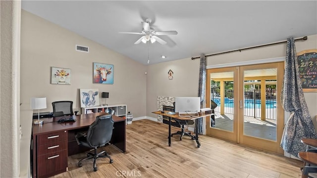 home office with visible vents, ceiling fan, vaulted ceiling, light wood-style floors, and french doors