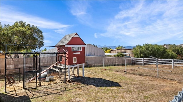 view of yard with an outbuilding, fence, and exterior structure