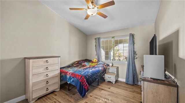 bedroom featuring lofted ceiling, light wood-style floors, baseboards, and ceiling fan