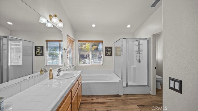 bathroom featuring vanity, wood finished floors, visible vents, a shower stall, and a garden tub