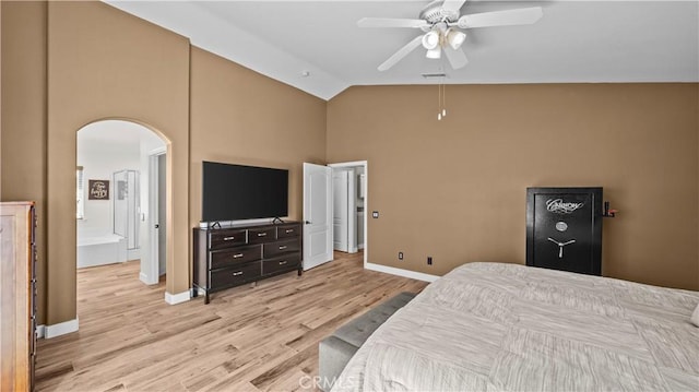 bedroom featuring visible vents, baseboards, light wood-style flooring, arched walkways, and vaulted ceiling