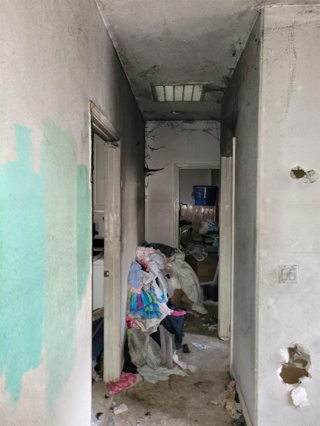 hallway with unfinished concrete flooring and visible vents