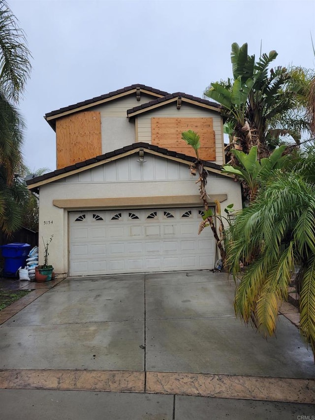 view of front facade featuring a garage, driveway, and stucco siding