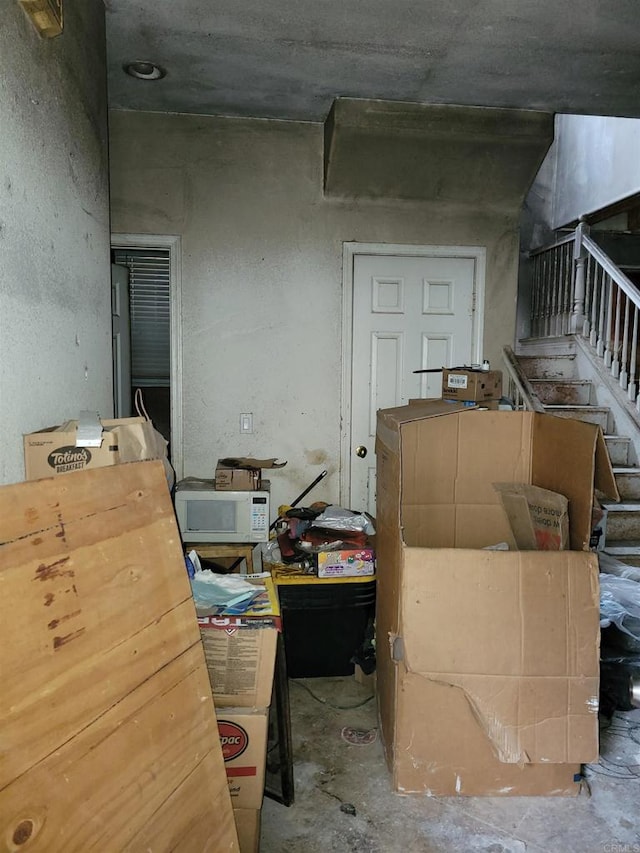 interior space featuring unfinished concrete floors and stairs