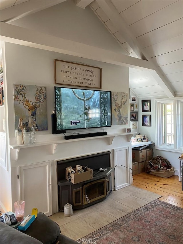 living area featuring vaulted ceiling with beams and light wood-type flooring