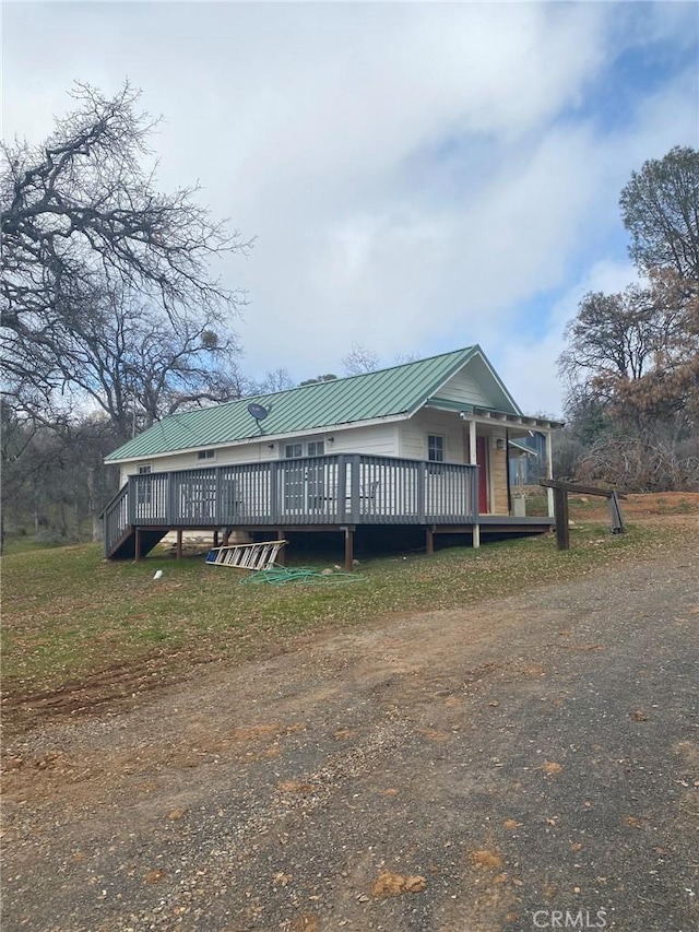 view of front of house featuring metal roof and a deck