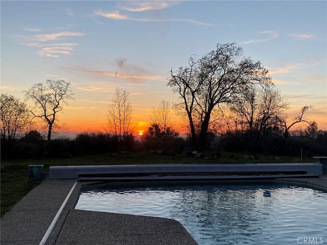 pool at dusk featuring an outdoor pool