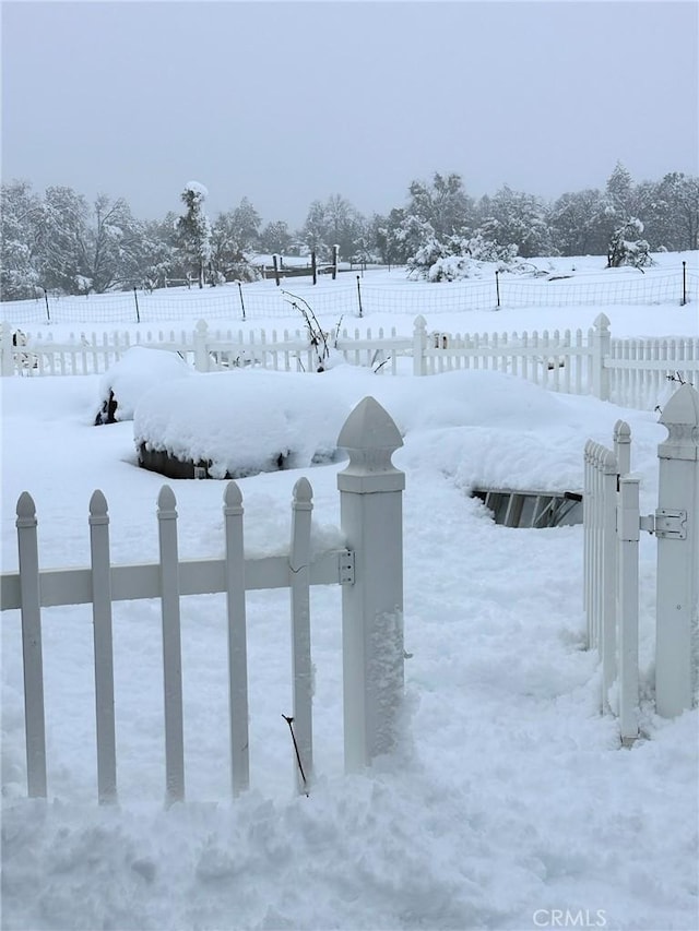 yard layered in snow with fence