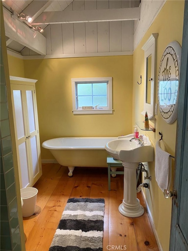 bathroom with a freestanding tub and hardwood / wood-style flooring