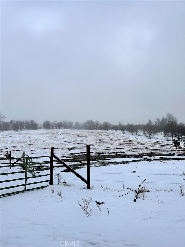 yard layered in snow featuring a rural view