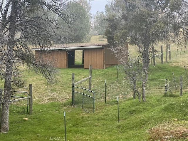 exterior space with an outbuilding, a pole building, a lawn, and fence