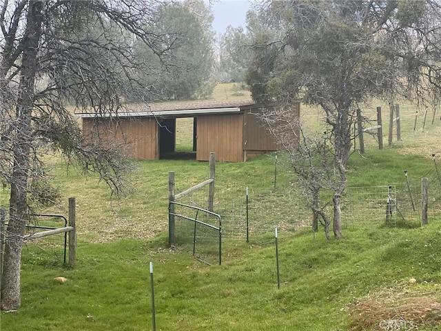 view of pole building featuring fence and a lawn