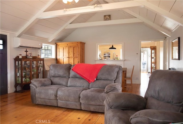 living area featuring light wood finished floors, lofted ceiling with beams, and a wall unit AC