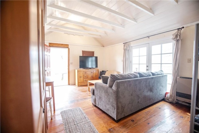 living area featuring light wood finished floors, french doors, and vaulted ceiling with beams