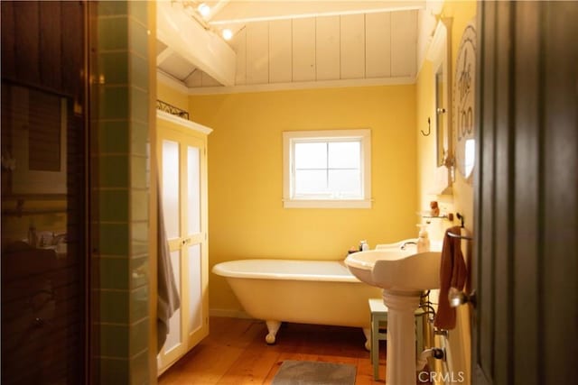 bathroom featuring a freestanding bath and wood finished floors