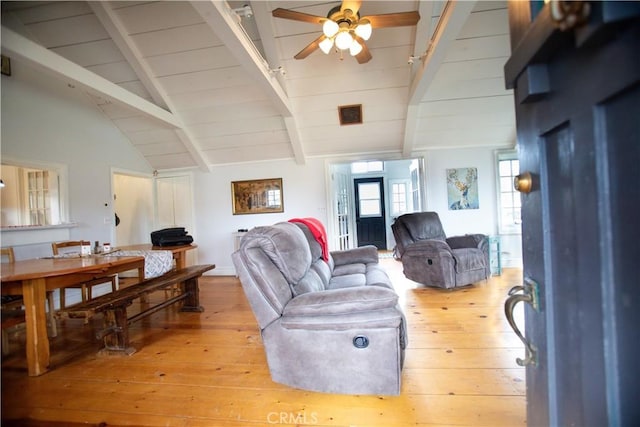 living area featuring a ceiling fan, lofted ceiling with beams, light wood-type flooring, visible vents, and wooden ceiling