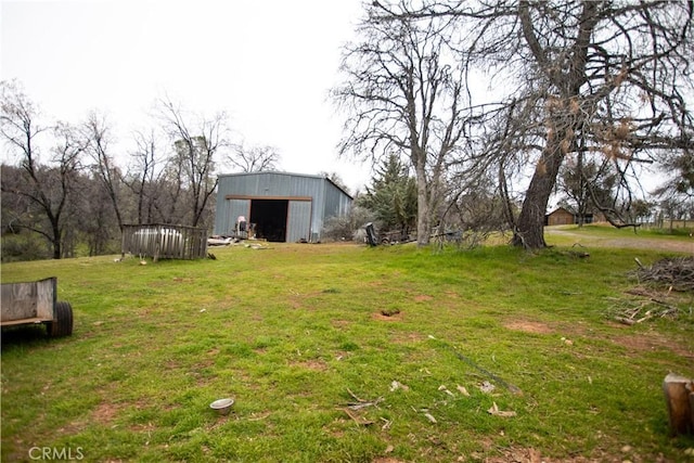 view of yard with an outbuilding, an outdoor structure, and a detached garage