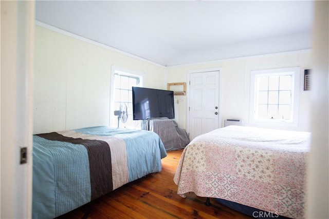 bedroom with crown molding and wood finished floors