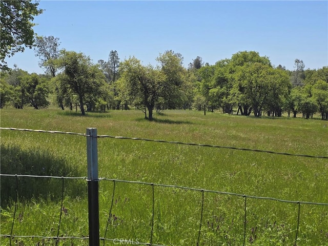 view of yard featuring fence and a rural view