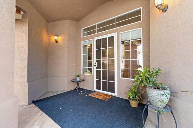 doorway to property featuring a patio area and stucco siding