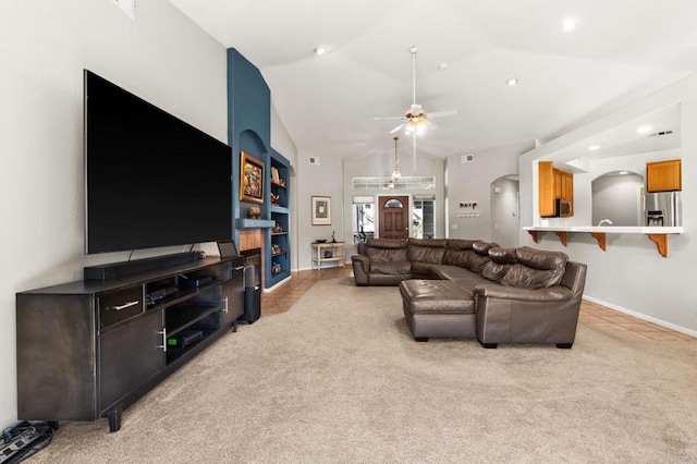 living room with ceiling fan, arched walkways, lofted ceiling, light carpet, and baseboards