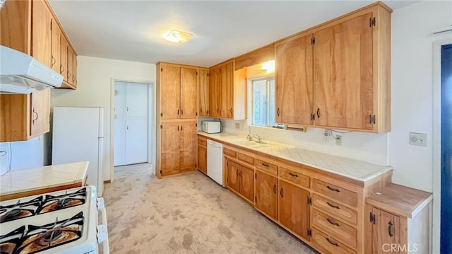 kitchen featuring tile countertops, under cabinet range hood, light carpet, white appliances, and a sink