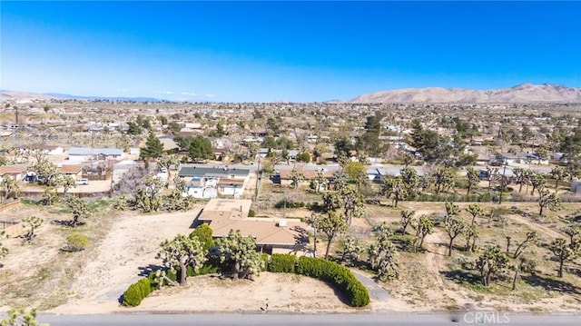 drone / aerial view featuring a desert view and a mountain view