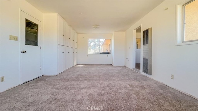 unfurnished room featuring light carpet