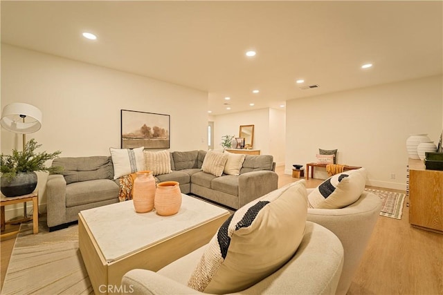 living area with recessed lighting, visible vents, light wood finished floors, and baseboards